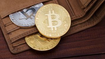 crypto currency coin in leather wallet on wide wood wooden background bitcoin ethereum litecoin iota ripple