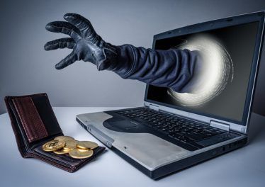 The abstract image of the hacker's hand reach through a laptop screen for stealing bitcoin in a wallet. the concept of cyber attack, virus, malware, cryptocurrency, illegally and cyber security.