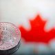 coins Bitcoin, against the background of Canada flag, concept of virtual money, close-up. Conceptual image of digital crypto currency.