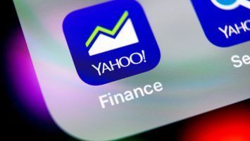 Yahoo finance application icon on Apple iPhone X smartphone screen close-up. Yahoo finance app icon. Social network. Social media icon