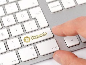 An image featuring a person pressing a custom key on a keyboard that says Dogecoin on it